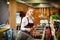 Happy satisfied woman adding condiments for taste in boiling pot with pasta sauce