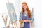 Happy satisfied woman painter finished painting picture in art studio