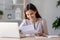 Happy satisfied woman sitting at desk reading positive letter