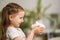 Happy savings. Close-up, little cute girl with white piggy Bank in her hands