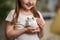 Happy savings. Close-up, little cute girl with white piggy Bank in her hands
