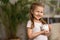 Happy savings. A little cute girl with a piggy Bank on the home background