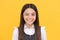 Happy school age girl child with smiling face give wink yellow background, winking