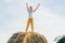 Happy school aged boy joyfully stand at top of haystack with raised arms. Carefree child on haymaking. Summer vacation.