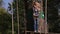 Happy school boy enjoying activity in a climbing adventure park on summer day.