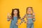 Happy school children friendship. best friends forever. small sisters have fun. little girls yellow background