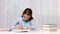 Happy school girl with books and notepad at home