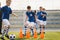 Happy School Kids Practice Soccer With Young Coach