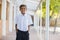 Happy schoolboy standing in corridor with hands in pocket