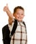 Happy schoolboy wearing backpack giving thumbs up