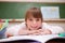 Happy schoolgirl leaning on a desk