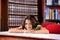 Happy Schoolgirl Resting Chin On Hands At Table In