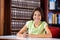 Happy Schoolgirl Sitting In Library