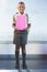 Happy schoolkid holding books and standing in classroom