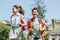 Happy schoolkids with backpacks smiling while running in park