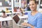 Happy schoolteacher standing in classroom with laptop