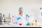 Happy scientist asian woman study and putting medical chemicals sample in test tube at laboratory