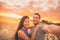 Happy selfie couple tourists on USA travel taking photo at sunset on Florida beach. Smiling Asian woman and Caucasian man,