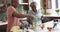 Happy senior african american female friends preparing meal in kitchen, copy space, slow motion