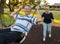 Happy senior American couple around 70 years old enjoying at swing park with wife pushing husband smiling and having fun together