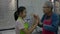 Happy senior Asian grandfather in apron playing and have fun together with his adorable young granddaughter in kitchen room.