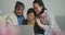 Happy senior asian mother, adult daughter and granddaughter in living room using laptop, embracing