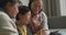 Happy senior asian mother, adult daughter and granddaughter in living room using tablet and laughing