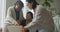 Happy senior asian mother, adult daughter and granddaughter sitting in living room using laptop