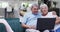 Happy senior biracial couple laughing and using tablet