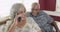 Happy senior black couple talking on smartphone at home