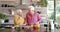 Happy senior caucasian couple cooking dinner in kitchen at home, slow motion