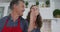 Happy senior caucasian couple in kitchen preparing meal, husband giving wife a taste and smiling