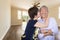 Happy Senior Chinese Couple Kissing Inside Empty Room Of New House.