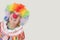 Happy senior clown looking up against gray background