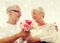 Happy senior couple with bunch of flowers at home