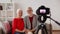 Happy senior couple with camera recording video