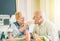 Happy senior couple eating pancakes at breakfast in a bar restaurant - Old people having fun enjoying meal at lunch