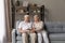 Happy senior couple enjoy conversation seated on sofa at home