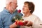 Happy Senior Couple with Gift and Red Rose