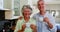 Happy senior couple having coffee in kitchen 4k