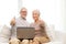 Happy senior couple with laptop at home