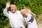 Happy senior couple outdoors waving hands