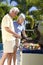 Happy Senior Couple Outside Cooking on A Barbecue