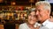 Happy senior couple posing on blurred casino hall background