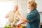Happy senior couple preparing breakfast with fruit and vegetables - Healthy lifestyle and jouyful elderly concept - Main focus on