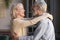 Happy senior couple relax dancing at home together