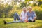 Happy senior couple relaxing in park playing chess together . old people sitting on grass in the summer park . Elderly resting .