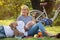 Happy senior couple relaxing in park  together. old people sitting on grass in the summer park . Elderly resting .mature