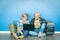 Happy senior couple sitting on floor with laptop at airport