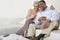 Happy Senior Couple Sitting On Sofa